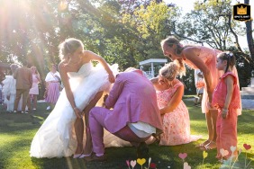 French château wedding: The groom calmly tries to remove a wasp from the bride's dress during the cocktail hour.